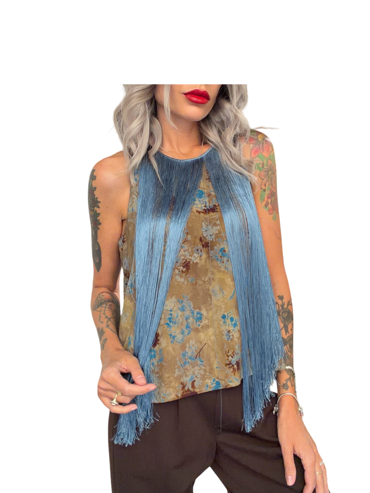 Modella indossa top smanicato Blaze Shop con fantasia floreale beige e lunghe frange azzurre su scollo rotondo