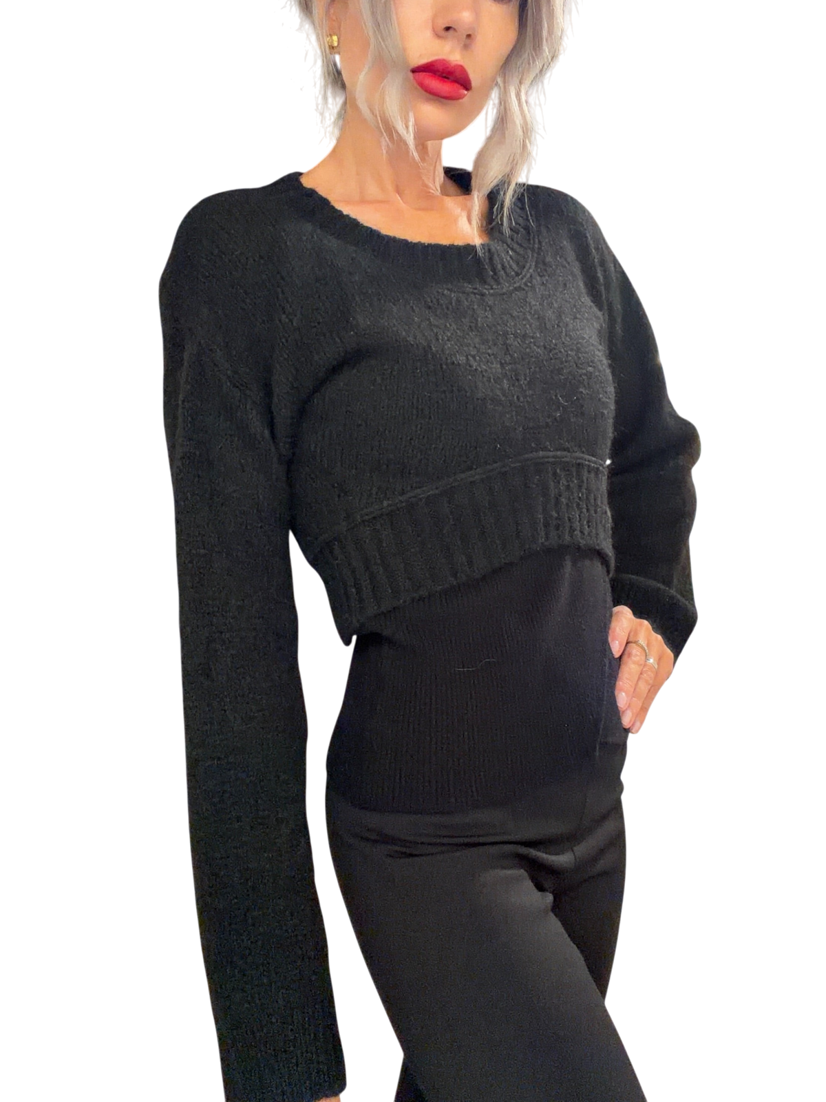 Modella indossa maglia crop nera Blaze Shop a coste con scollo rotondo in un negozio di abbigliamento
