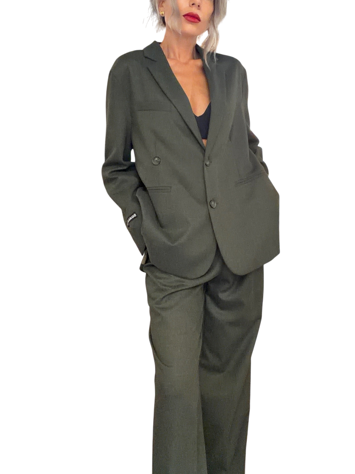 Modella indossa giacca doppiopetto oversize verde loden Blaze Shop con revers ampi e logo sul polso in negozio