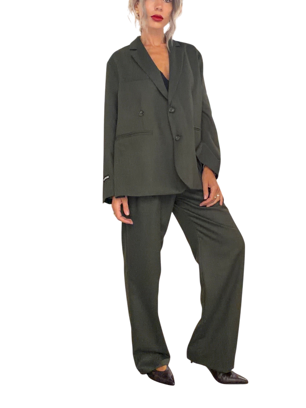 Modella indossa giacca doppiopetto oversize verde loden Blaze Shop con pantaloni coordinati in un negozio di abbigliamento