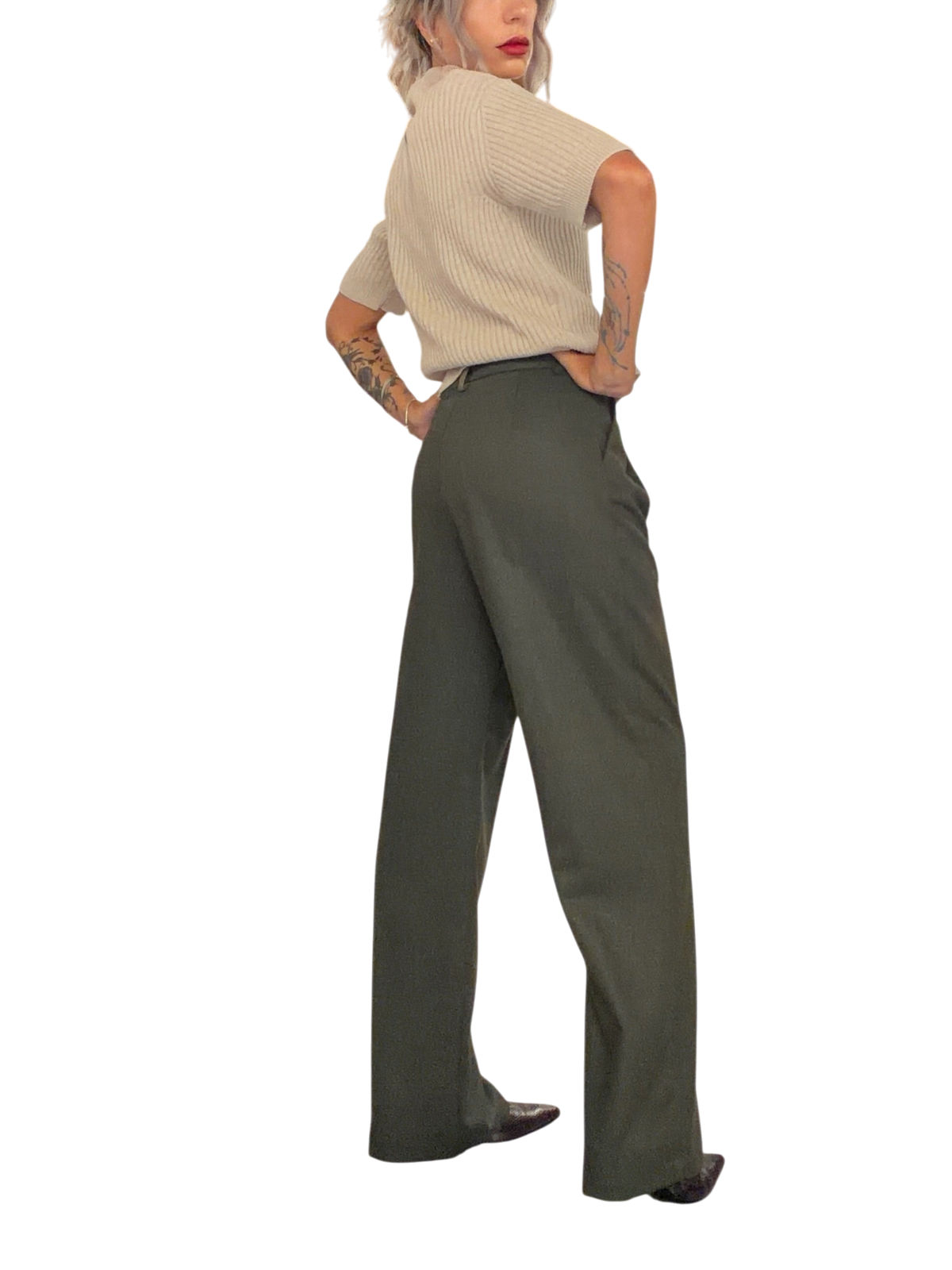 Modella indossa pantaloni palazzo Blaze Shop verde loden a vita alta con gamba ampia in un negozio di abbigliamento