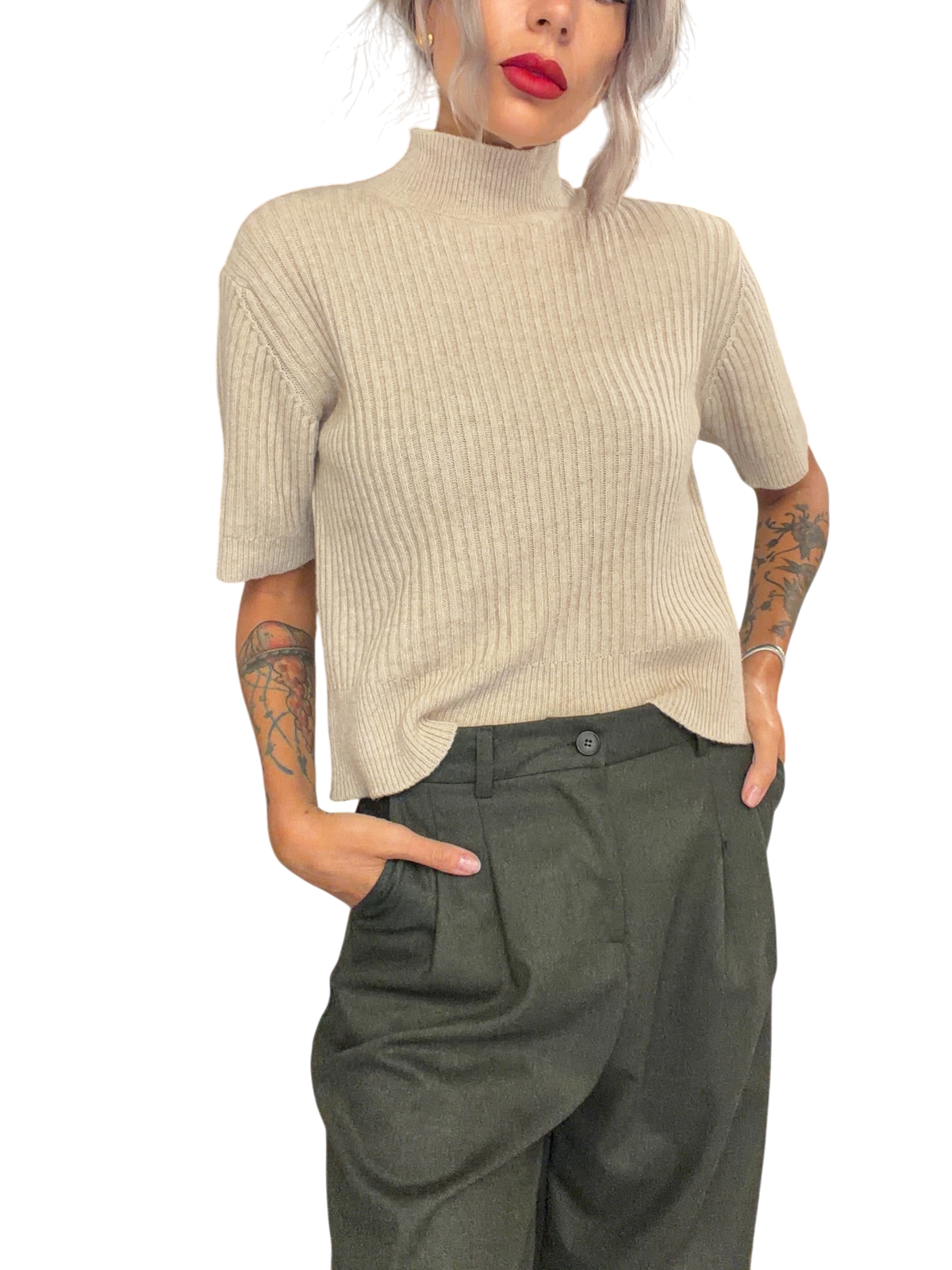 Modella indossa maglia Blaze Shop color avena a coste con collo alto e maniche corte in un negozio di abbigliamento