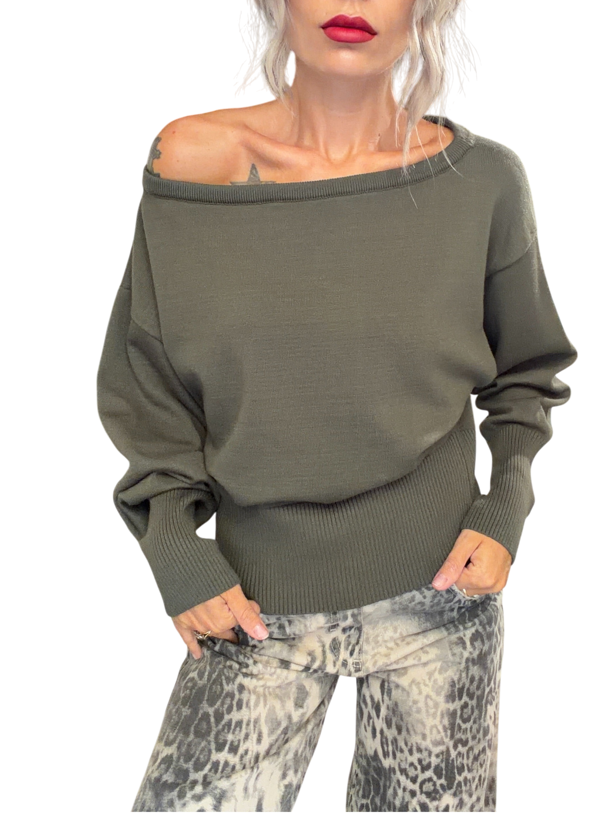Modella indossa maglia Blaze Shop verde loden con scollo a barca, maniche ampie e fondo a coste in un negozio