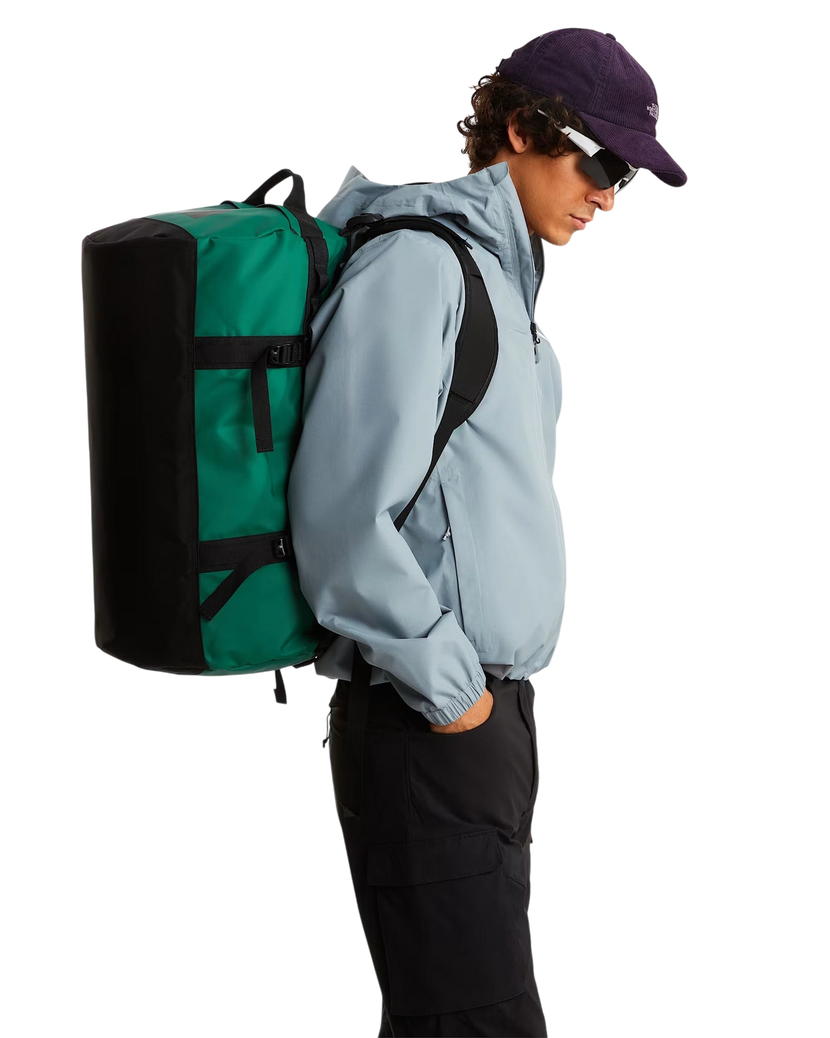 Modello indossa il borsone Blaze Shop THE NORTH FACE Base Camp Duffel 50L verde e nero come zaino su sfondo bianco