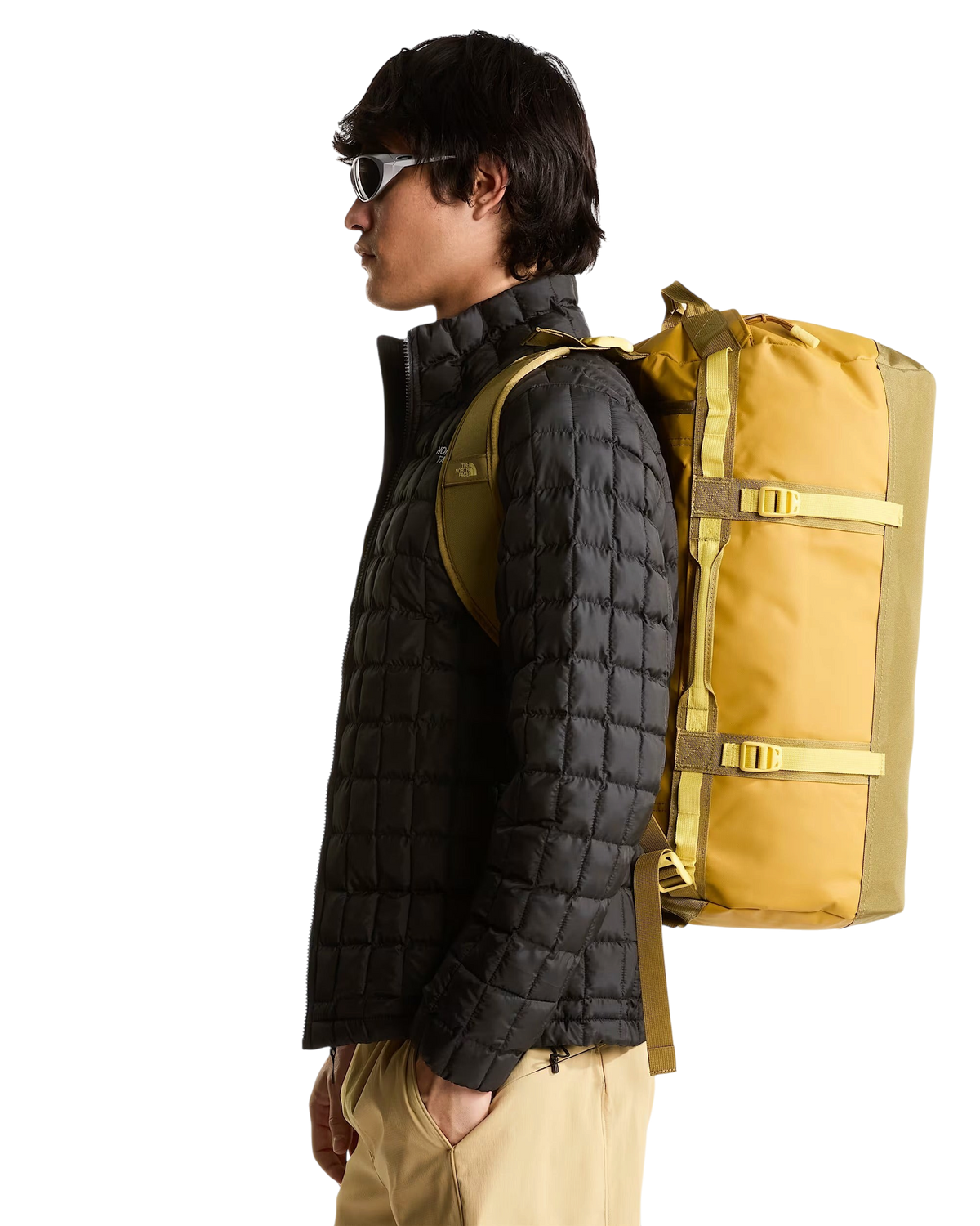 Modello indossa il borsone Blaze Shop The North Face Base Camp Duffel 50L color sabbia e oro come zaino