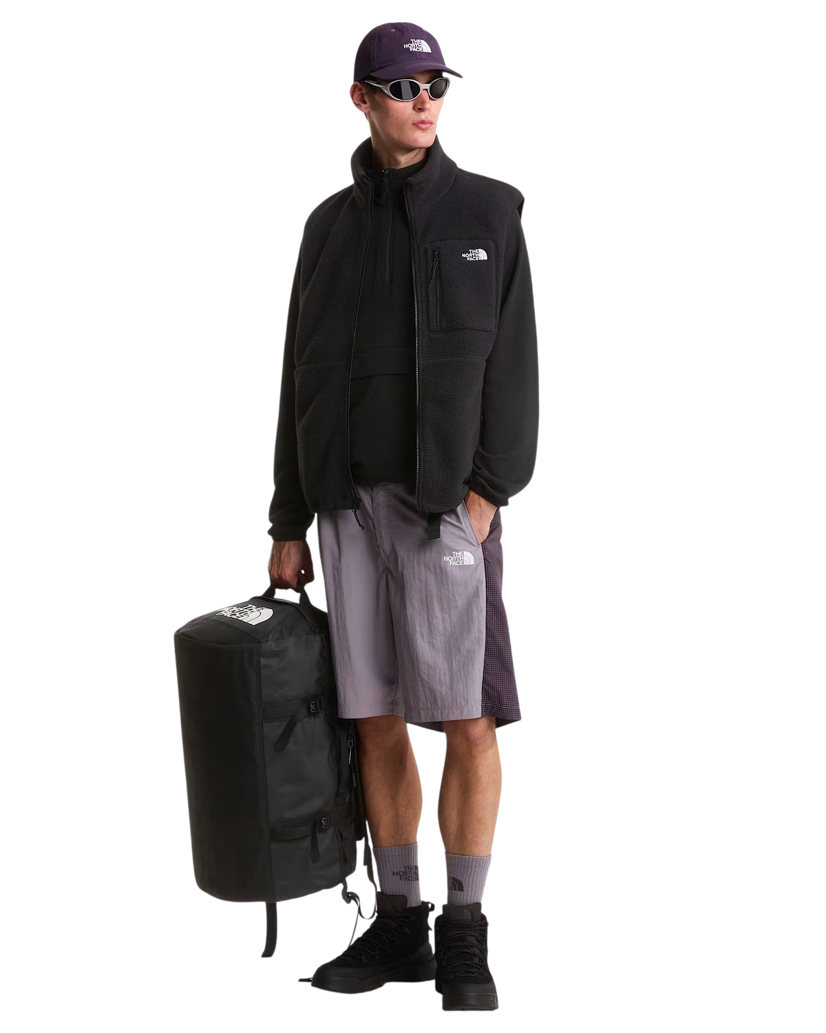 Modello Blaze Shop indossa abbigliamento The North Face e tiene in mano il borsone nero Base Camp Duffel da 50 litri