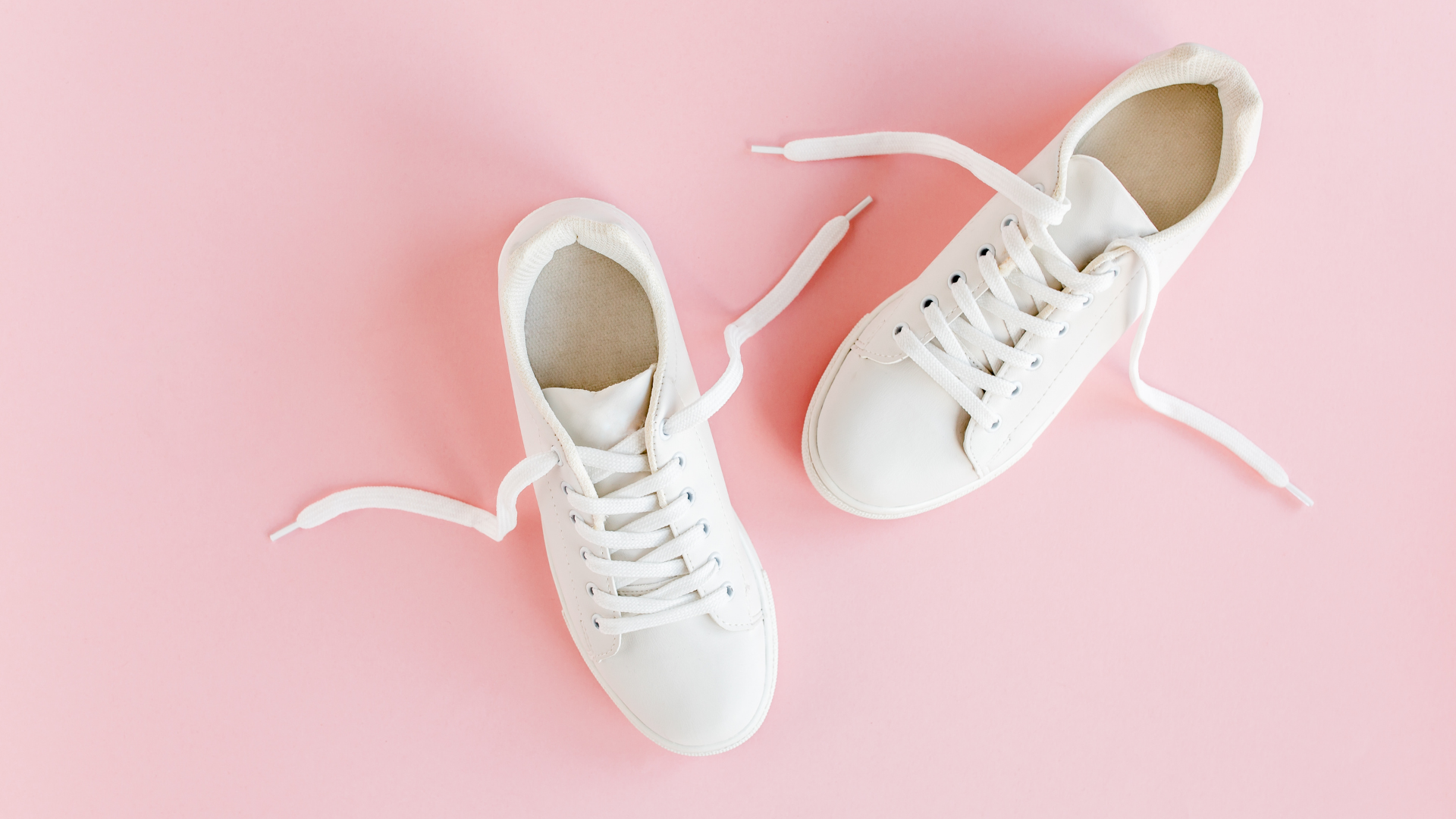 Scarpe da ginnastica bianche su sfondo rosa